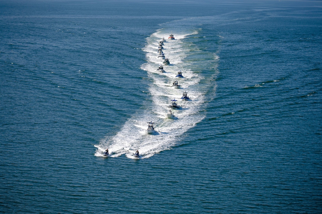 A large group of vessels move through the water.