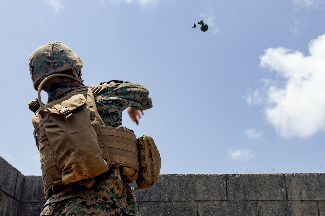 A U.S. Marine with III Marine Expeditionary Force Support Battalion, III MEF, throws a M67 fragmentation grenade during a live-fire grenade range on Camp Hansen, Okinawa, Japan, May 16, 2023. III MSB conducted grenade handling and safety training before a live-fire grenade range meant to increase lethality and readiness among the Marines.