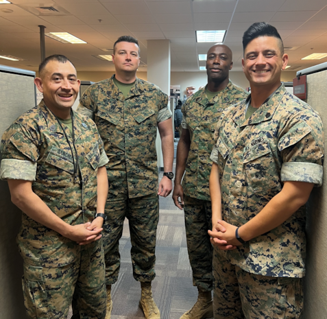 Enlisted Marines stationed at Marine Corps Systems Command pose for a photo at the Portfolio Manager for Command Element Systems building in Stafford, Virginia. Pictured left to right: Gunnery Sgt. Anibal Sanchez, Signature Management project chief; Master Sgt. Louis Ignarro, Sensitive Compartmented Information communications project officer; Master Gunnery Sgt. Judah Crawford, senior enlisted advisor; Gunnery Sgt. Gabriel Vila, project officer for Integrated Broadcast Receiver. Enlisted Marines serve as the connective tissue between MARCORSYSCOM and the fleet, allowing better communication throughout the acquisition process. (U.S. Marine Corps courtesy photo)