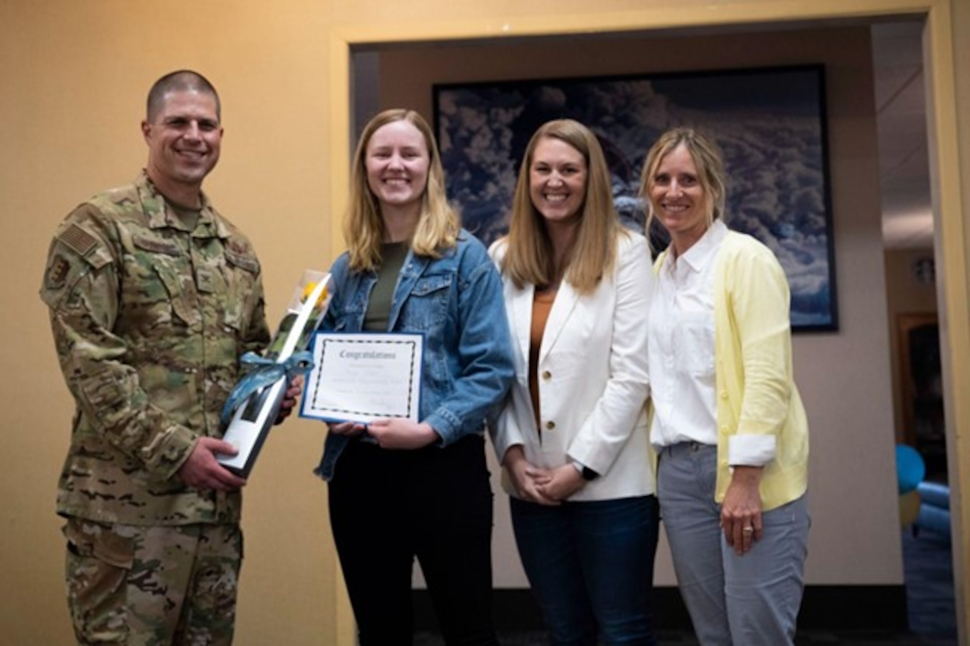 U.S. Air Force Col. Seth Spanier (left), presents a scholarship to a yearly winner along with members of the Team Ellsworth Spouse Club at Ellsworth Air Force Base, S.D., May 11, 2023. This year’s scholarship was awarded to three spouses for $1,500 each. (U.S. Air Force photo by Airman 1st Class Josephine Pepin)