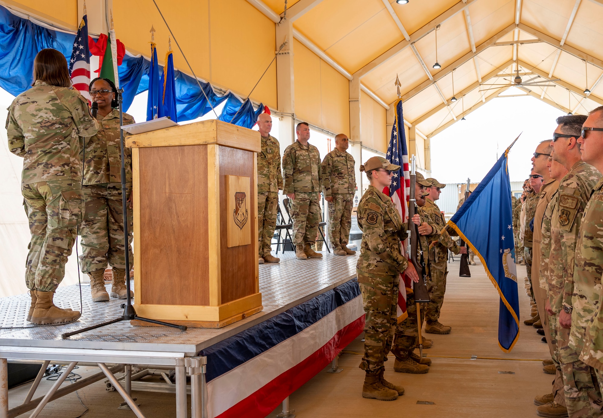 U.S. Airmen with the 378th Air Expeditionary Wing Honor Guard present colors while the national anthem is sung during a change of command ceremony at Prince Sultan Air Base, Kingdom of Saudi Arabia, May 18, 2023. During the ceremony, Brig. Gen. William Betts relinquished command of the 378th AEW to Brig. Gen. Akshai Gandhi. The tradition of change of command ceremonies are to allow service members to witness their new leader assume the responsibility and trust associated with the position of commander. (U.S. Air Force photo by Senior Airman Stephani Barge)