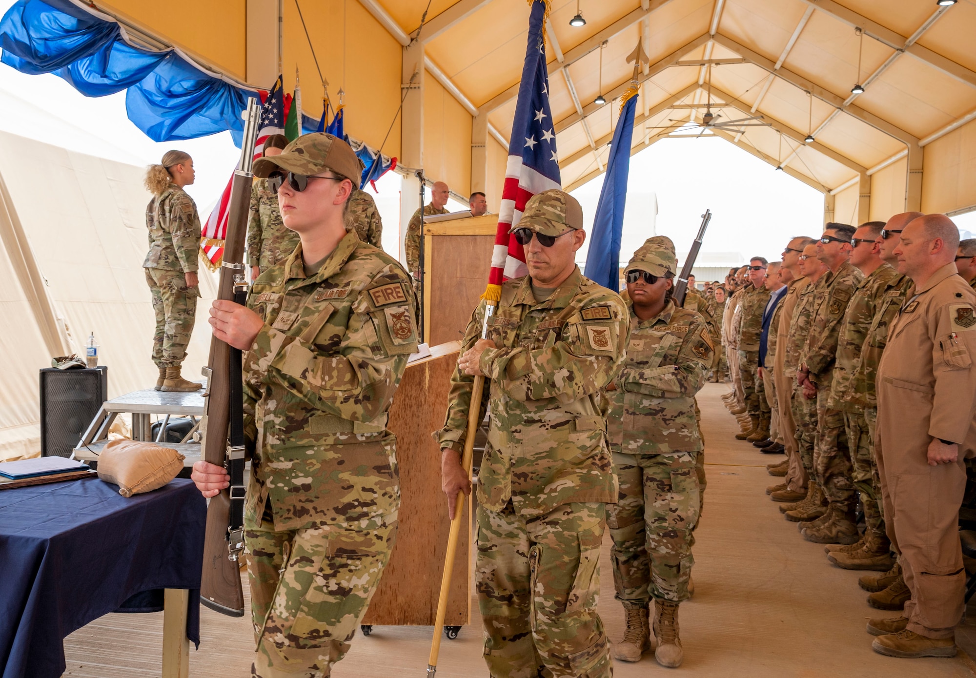 U.S. Airmen with the 378th Air Expeditionary Wing Honor Guard present colors during a change of command ceremony at Prince Sultan Air Base, Kingdom of Saudi Arabia, May 18, 2023. During the ceremony, Brig. Gen. William Betts relinquished command of the 378th AEW to Brig. Gen. Akshai Gandhi. The tradition of change of command ceremonies are to allow service members to witness their new leader assume the responsibility and trust associated with the position of commander. (U.S. Air Force photo by Senior Airman Stephani Barge)