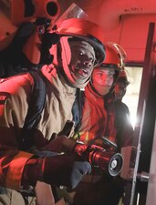Sailors fight a simulated fire during a general quarters drill aboard  USS Milius (DDG 69) in the Philippine Sea.