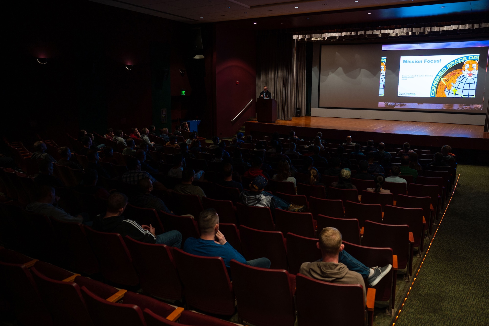 Members of Space Delta 5 (DEL 5) listen to Royal Australian Air Force Group Captain Julian Greening, Combined Space Operations Center (CSpOC) deputy director, provide a CSpOC and DEL 5-mission brief to start off DEL 5’s ‘Gemini’ at the Base Theater on Vandenberg Space Force Base, Calif., April 7, 2023. Greening’s mission brief specifically targeted Guardians in the Specialist-tier, to help them to better understand their importance and direct impact to the mission they provide. (U.S. Space Force photo by Tech. Sgt. Luke Kitterman)