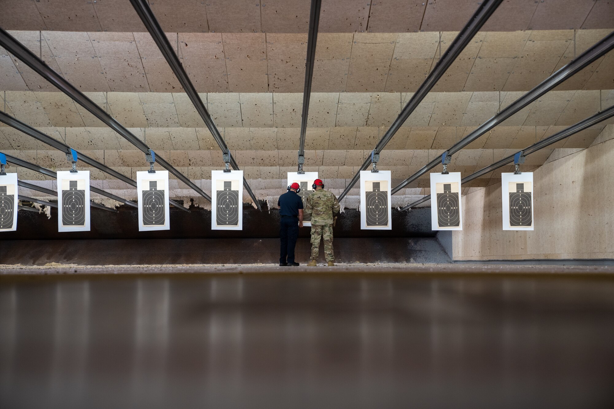 Officer Zach Kaletsch and Staff Sgt. David Evens, 81st Security Forces Squadron combat arms instructors, review and score targets during the National Police Week pistol competition at Keesler Air Force Base, Mississippi, May 17, 2023.