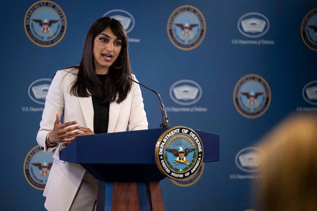 A woman stands behind a lectern.