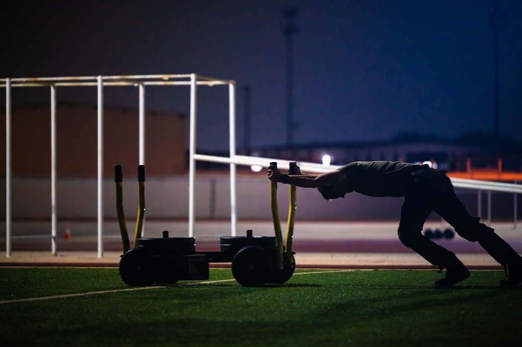Student pushes weighted sled at sunrise