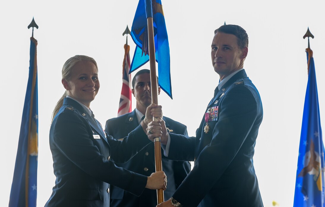 Col. Michele Lo Bianco, 15th Wing commander, receives the 15th Operations Group guidon from Col. Garrett Fisher, 15th OG outgoing commander, after he relinquishes command during a change of command ceremony on Joint Base Pearl Harbor-Hickam, Hawaii, May 12, 2023. Fisher assumed command on July 9, 2021, directing all activities and ensuring combat readiness within four operational squadrons. (U.S. Air Force photo by Staff Sgt. Alan Ricker)