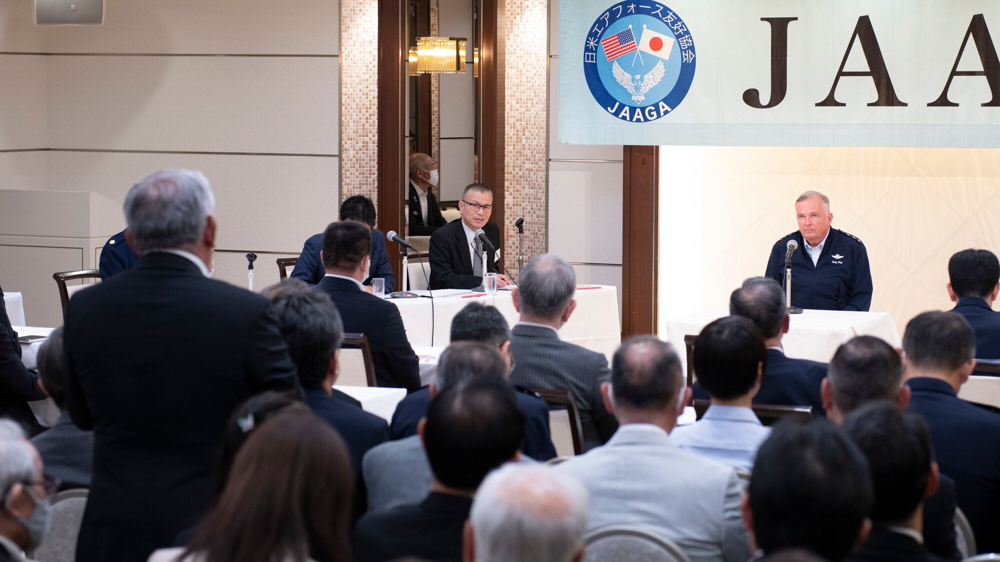 A man sitting at a table facing an seated audience