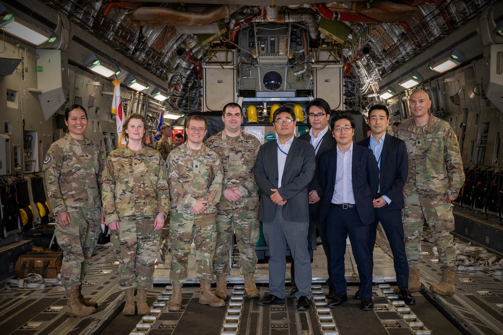 Members from the U.S Space Force Space Systems Command and Japanese National Space Policy Secretariat pose for a photo in front of a satellite payload at Yokota Air Base, Japan, May 10, 2023.
