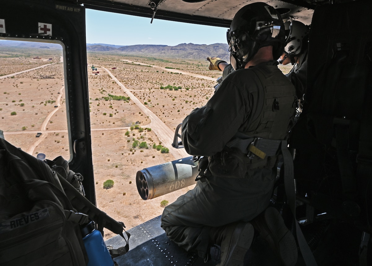U.S. Marine Corps Master Sgt. Zachary Franks, Marine Light Attack Helicopter Squadron 775 crew chief instructor, shows Lance Cpl. Rei Kitamura, HMLA 775 crew chief, simulated opposition forces during the RED FLAG-Rescue 23-1 training exercise over various places in Arizona and New Mexico, May 13, 2023. Morales trained with joint service and multinational partners while attending RF-R 23-1, and he learned communication skills, enhanced perspectives, and built relationships with coalition partners for future conflicts. (U.S. Air Force photo by Staff Sgt. Abbey Rieves)