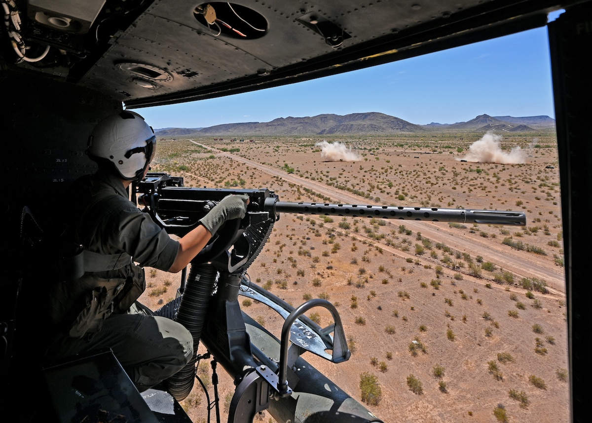 U.S. Marine Corps Lance Cpl. Elijah Morales, Marine Light Attack Helicopter Squadron 775 crew chief, looks back at his shots fired during the RED FLAG Rescue 23-1 training exercise over various places in Arizona and New Mexico, May 13, 2023. The exercise was stacked with simulated enemy structures, armored vehicles, and mock adversary personnel to develop aerial shooting skills. (U.S. Air Force photo by Staff Sgt. Abbey Rieves)