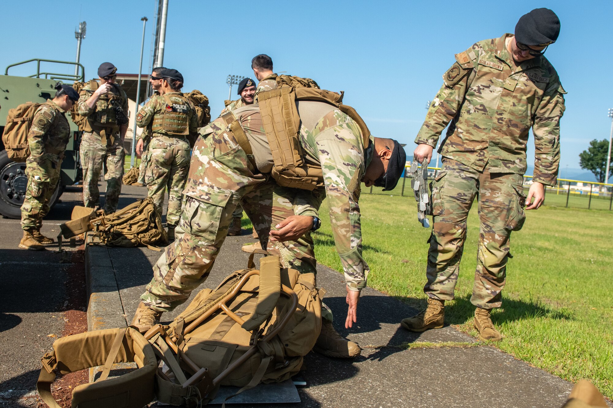 Military members add weights to backpacks for a ruck march.