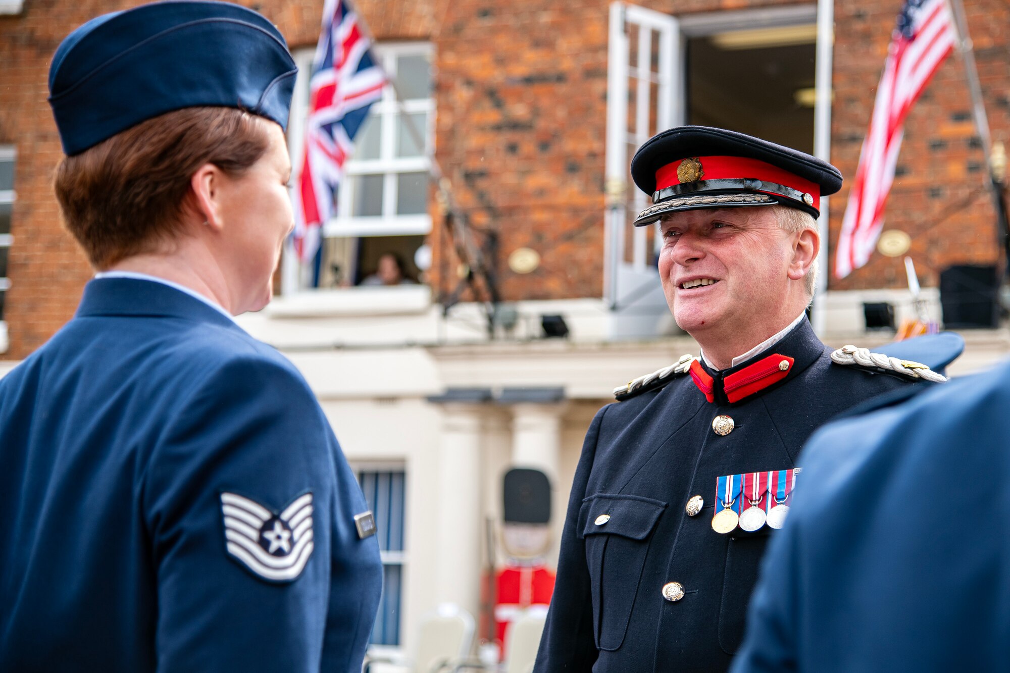 Brigadier Tim Seal, left, Deputy Lieutenance of Cambridgeshire, speaks with an Airman from 501st Combat Support Wing, in Huntingdon, England, May 19, 2023. In 2018 the 501st CSW was granted their freedom, an ancient tradition and high honor, by the city of Huntingdon and today Airmen exercised that freedom alongside local community members. (U.S. Air Force photo by Staff Sgt. Eugene Oliver)