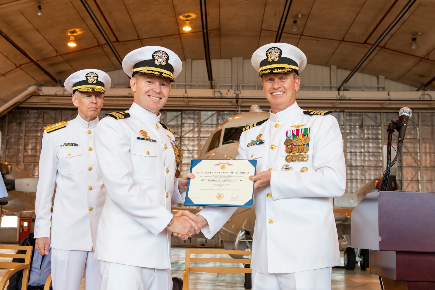 Capt. Gregory Petrovic (right), U.S. Naval Research Laboratory (NRL) commanding officer, presents a Meritorious Service Medal to Cmdr. Jeffrey Webb (left), NRL’s Scientific Development Squadron (VXS) 1 outgoing commanding officer, during the VXS 1 change of command ceremony at Naval Air Station Patuxent River in Patuxent River, Maryland, May 18, 2023. (U.S. Navy photo by Sarah Peterson)