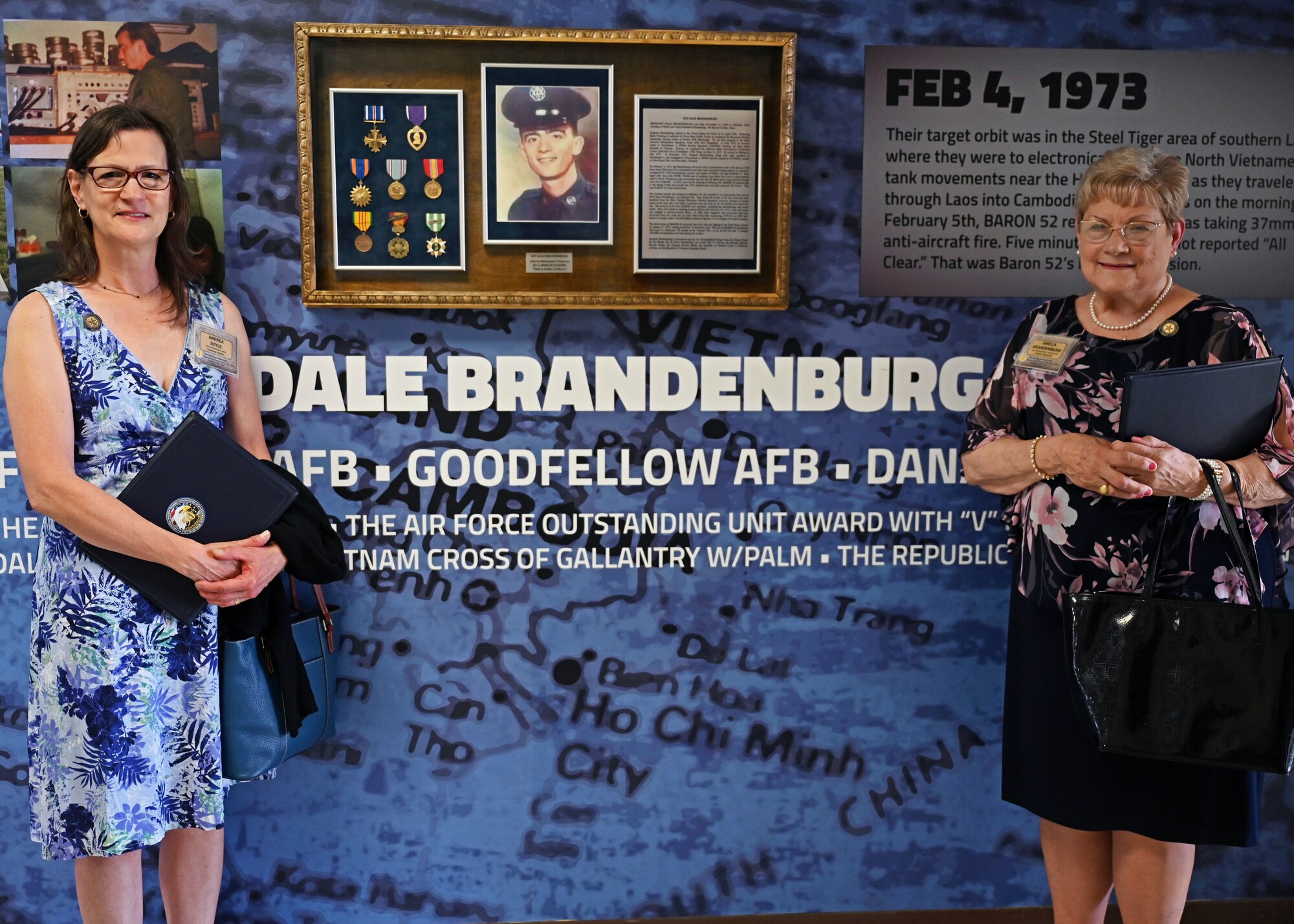 U.S. Air Force Sgt. Dale Brandenburg’s sister-in-law, Amelia Brandenburg, and his niece, Andrea Doyal, stand at Brandenburg Hall, Goodfellow Air Force Base, Texas, May 12, 2023. The building was rededicated because of the newly finished mural memorial. (U.S. Air Force photo by Senior Airman Sarah Williams)