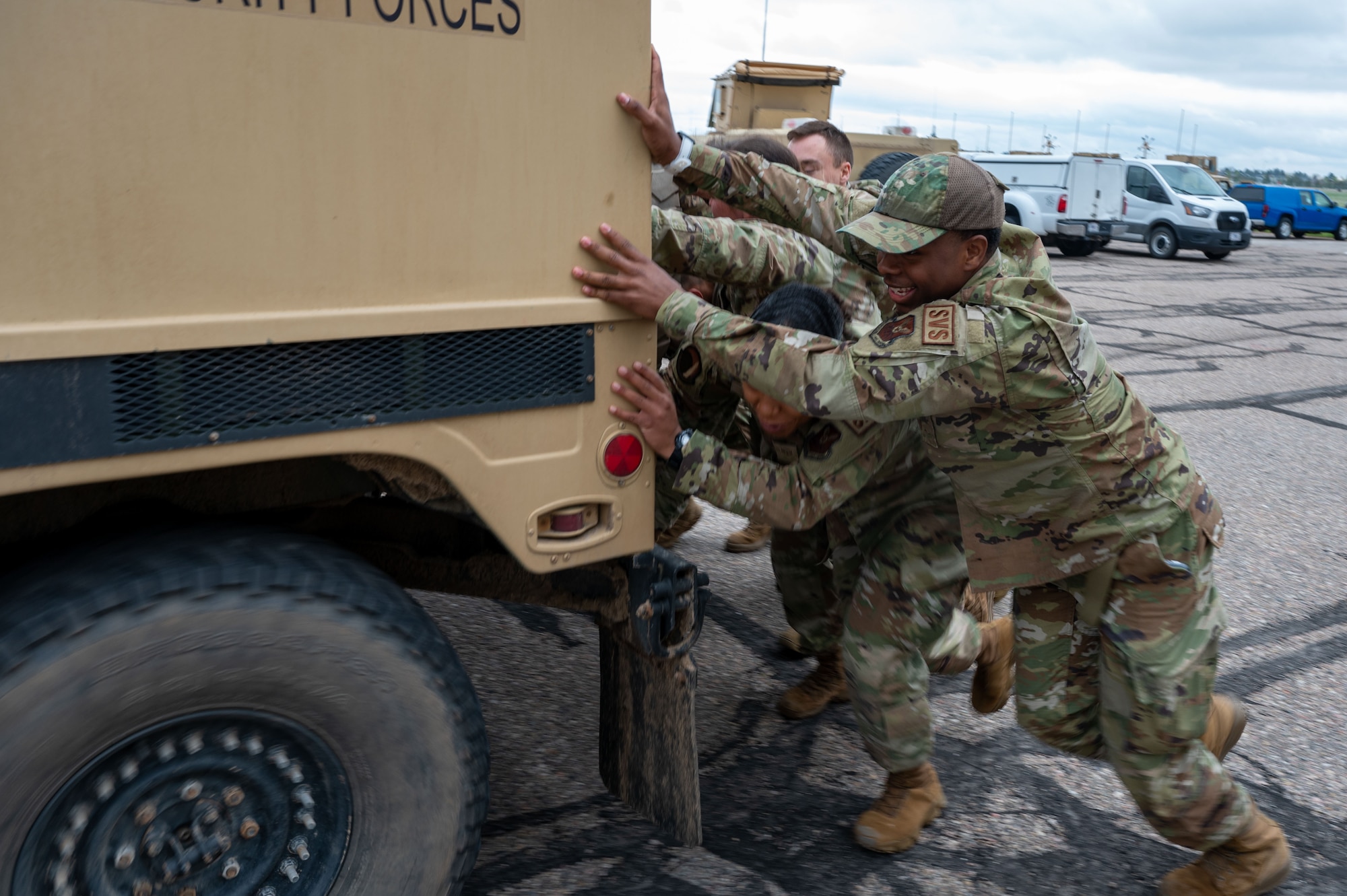 airmen pushing vehicle