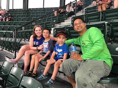 Mother, two children and father sit in stadium seats
