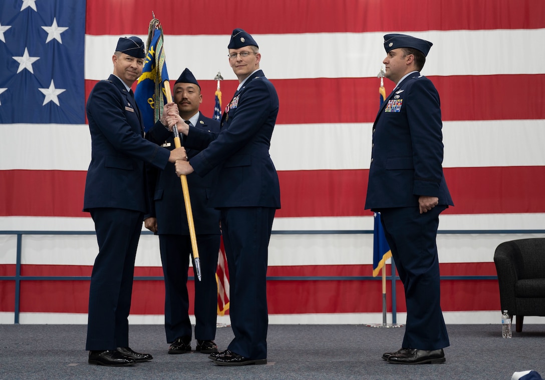 U.S. Air Force Col. Timothy Monroe, 25th Attack Group commander, relinquishes Lt. Col. Christopher Billau, 89th Attack Squadron outgoing commander, of his command of the 89 ATKS at Ellsworth Air Force Base, South Dakota, May 18, 2023.