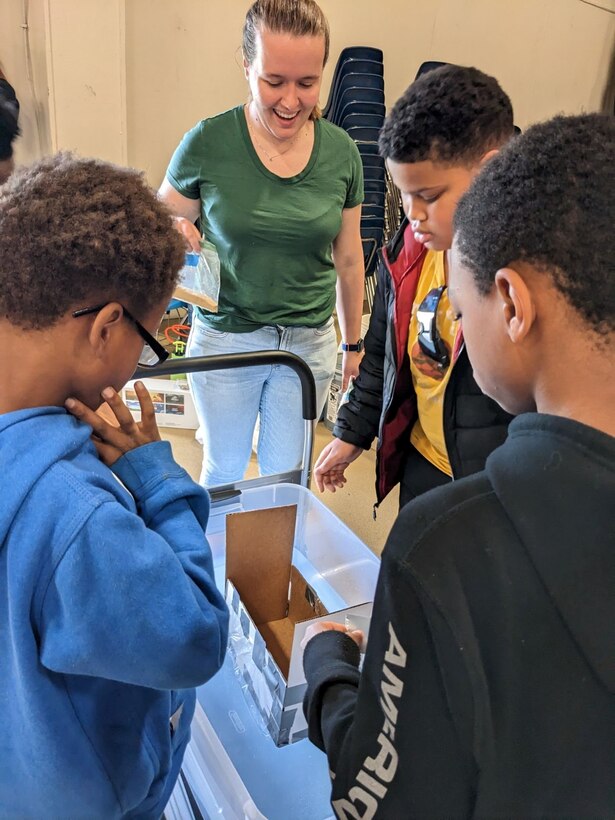 IMAGE: From left to right, Montross Middle School 6th graders Zylitue Banks, Latrell Purce and Jayleen Reeves are participating in the Load Bearing Boat Build Challenge. Naval Surface Warfare Center Dahlgren Division (NSWCDD) scientist Stephanie Shand is assisting the students. The Load Bearing Boat Build challenge was one of three at the STEM competitions for the whole school.