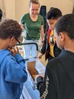 IMAGE: From left to right, Montross Middle School 6th graders Zylitue Banks, Latrell Purce and Jayleen Reeves are participating in the Load Bearing Boat Build Challenge. Naval Surface Warfare Center Dahlgren Division (NSWCDD) scientist Stephanie Shand is assisting the students. The Load Bearing Boat Build challenge was one of three at the STEM competitions for the whole school.