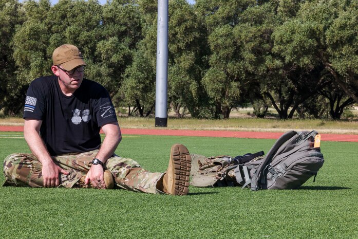 U.S. Air Force Master Sgt. Jason Thomas, 9th Security Forces Squadron installation security section chief, stretches after completing the police week 9K ruck march on May 15, 2023, at Beale Air Force Base, California.