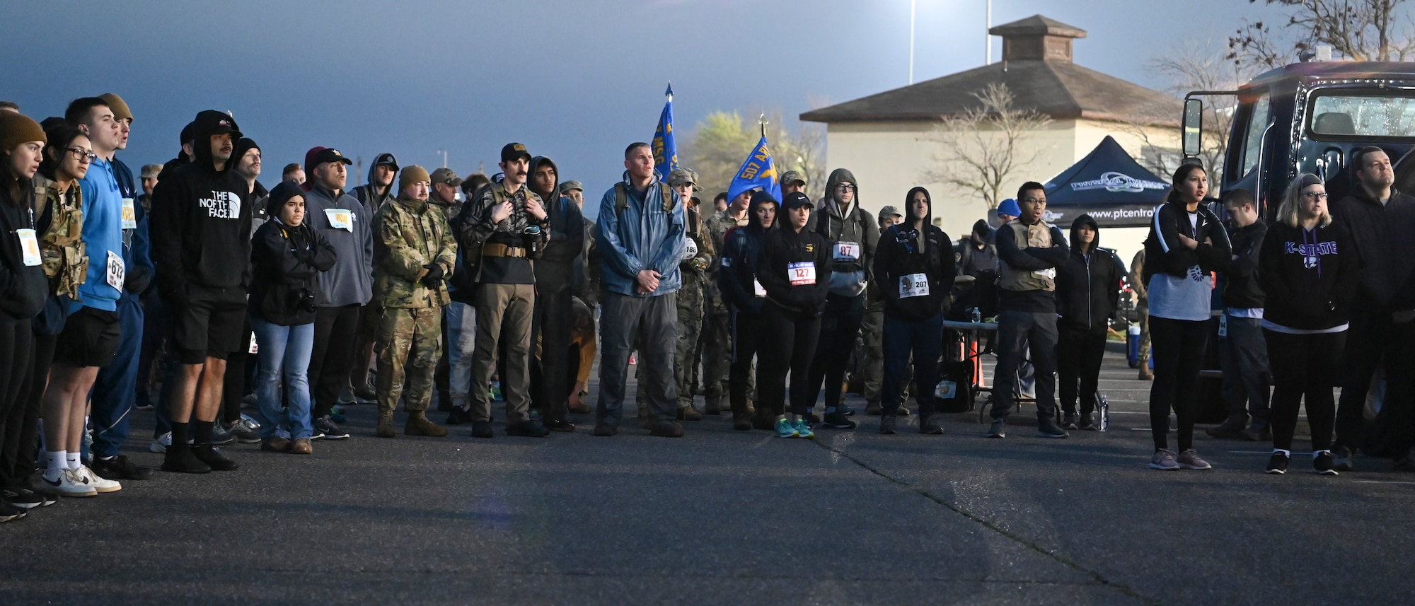 Men and women standing during opening remarks before dawn