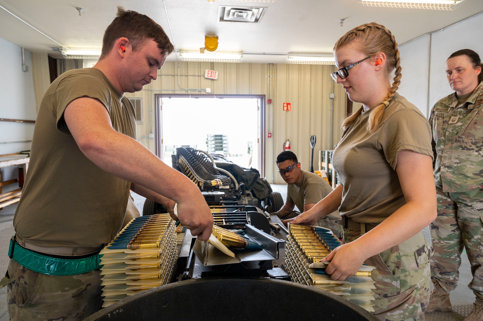 U.S. Air Force Senior Airman Chad Erwin, 49th Equipment Maintenance Squadron conventional maintenance crew member, left, feeds 20mm ammunition into a belt with U.S. Air Force Airman 1st Class Samantha Steenbergh, 49th EMS conventional maintenance crew member, at Holloman Air Force Base, New Mexico, May 18, 2023.