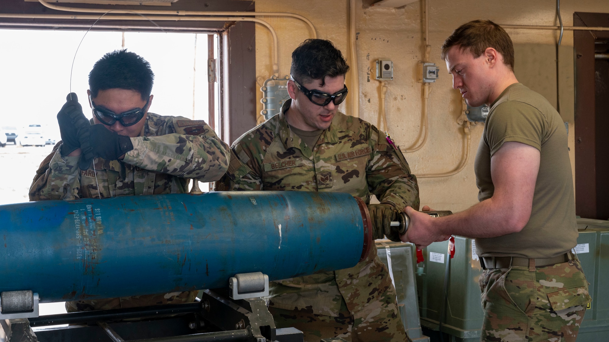 U.S. Air Force Tech. Sgt. Richard Fardy, 49th Equipment Maintenance Squadron munitions inspector, left, undergoes combat munitions training with U.S. Air Force Staff Sgt. Rodney Belcher, 49th EMS conventional maintenance crew chief, center, and U.S. Air Force Airman Jeremiah McFarland, precision guided munitions crew member, at Holloman Air Force Base, New Mexico, May 18, 2023.