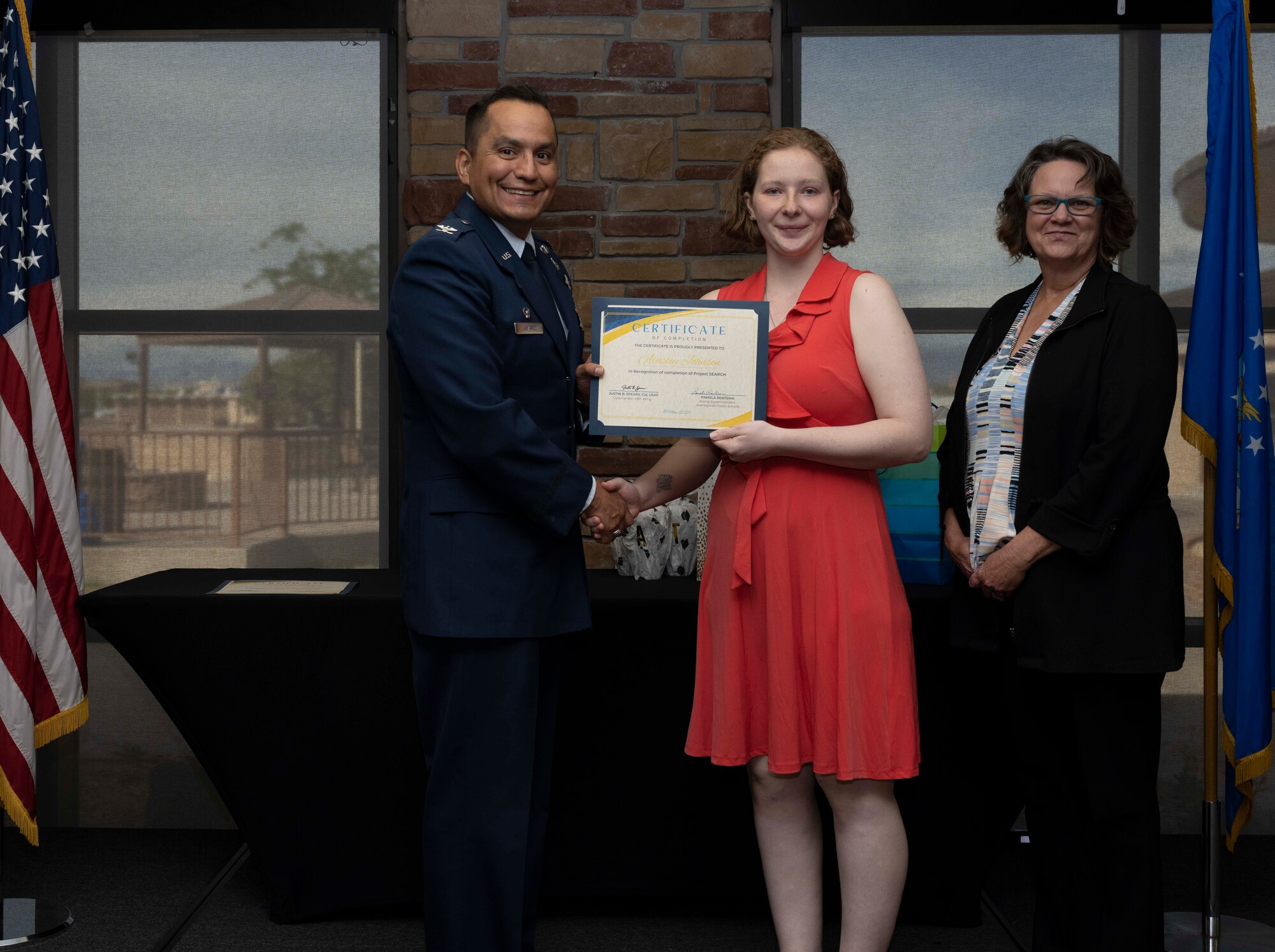 Ainsley Johnson, Project SEARCH intern, accepts a graduation certificate for completing the Project Search program at Holloman Air Force Base, New Mexico, May 18, 2023. Project SEARCH integrates 18-22 year olds with disabilities into working environments to help them gain valuable work experience. (U.S. Air Force photo by Airman 1st Class Michelle Ferrari)