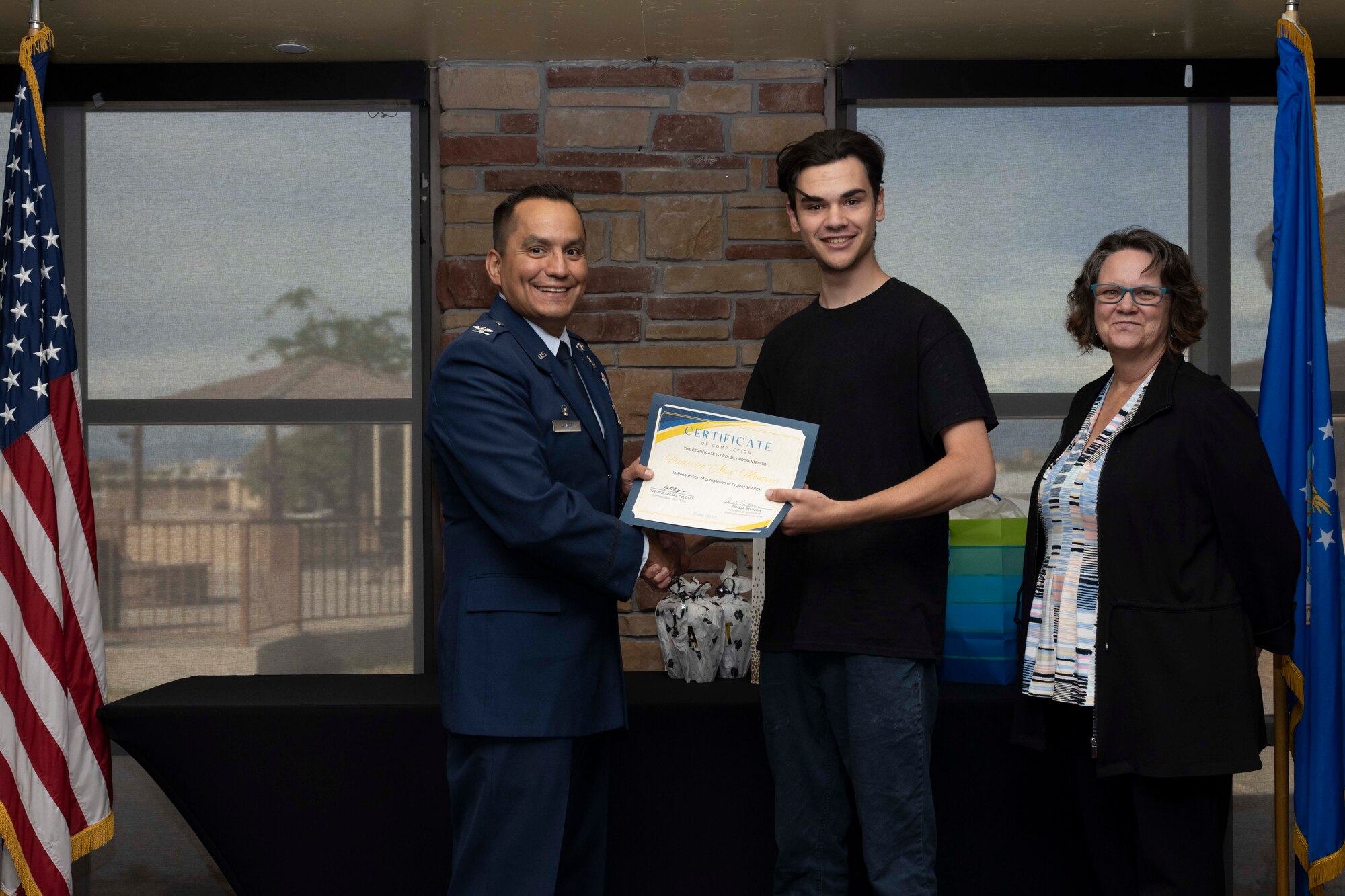 Alex Montoya, Project SEARCH intern, accepts a graduation certificate for completing the Project Search program at Holloman Air Force Base, New Mexico, May 18, 2023. Project SEARCH integrates 18-22 year olds with disabilities into working environments to help them gain valuable work experience. (U.S. Air Force photo by Airman 1st Class Michelle Ferrari)