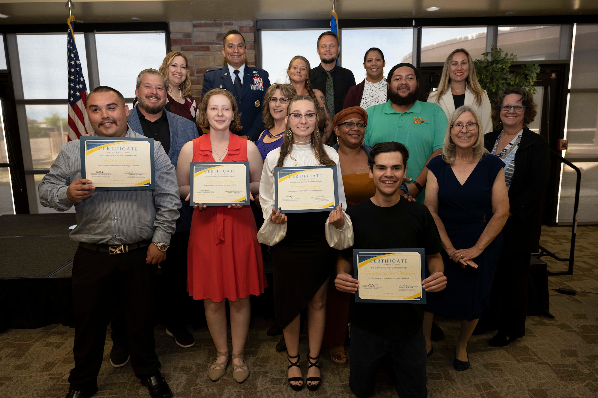 Project SEARCH stakeholders and graduates pose for a photo after a graduation ceremony at Holloman Air Force Base, New Mexico, May 18, 2023. Holloman is the only military installation in New Mexico to participate in Project SEARCH, a program that integrates 18-22 year olds with disabilities into working environments to help them gain valuable work experience. (U.S. Air Force photo by Airman 1st Class Michelle Ferrari)