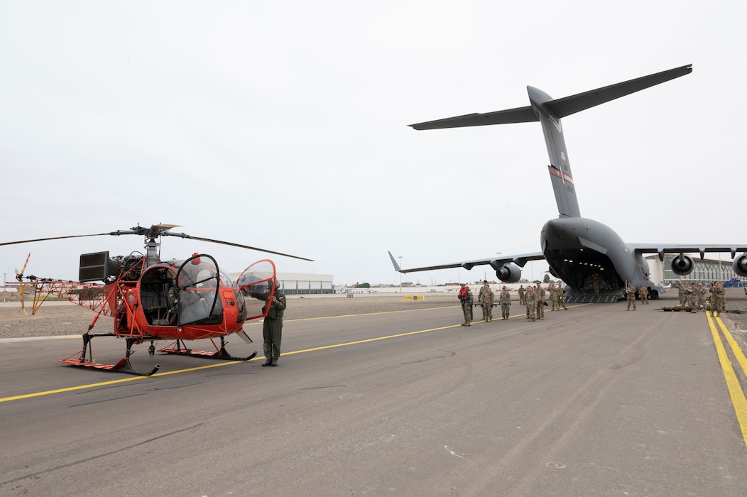 West Virginia Air National Guard personnel wait to transfer a simulated patient from an Argentine Lama SA-315B, high altitude rescue helicopter, to a C-17 Globemaster aircraft as part of a patient transport scenario at Pisco Air Base, Peru, May 10, 2023, as part of Cooperacion IX.