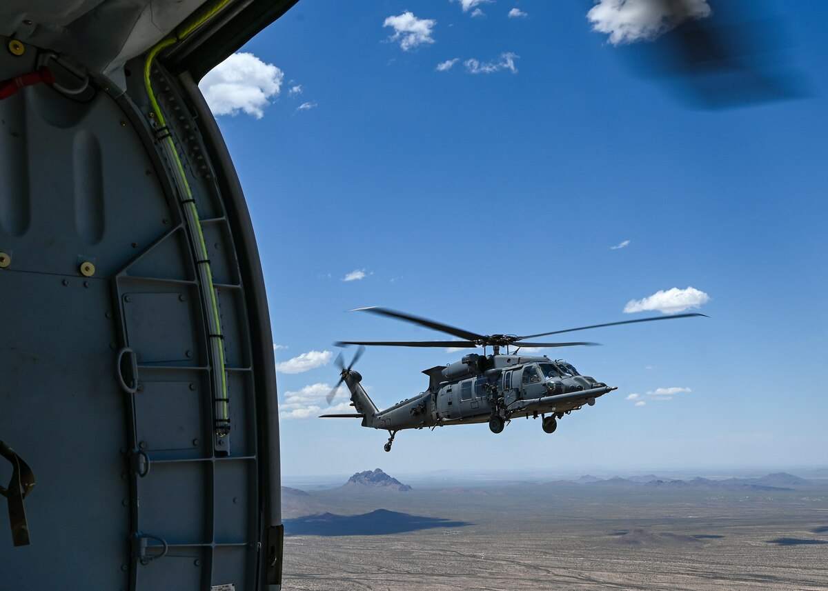 A helicopter flies over the desert.