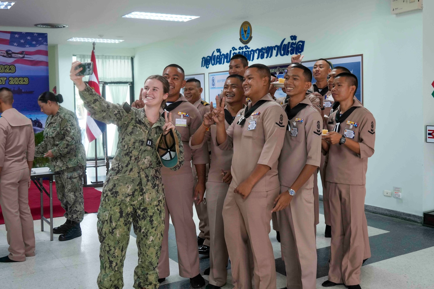 U.S. Navy Lt. Gabrielle Panchevre takes a photo with Royal Thai Navy Sailors during the closing ceremony of Cooperation Afloat Readiness and Training (CARAT)/Marine Exercise (MAREX) Thailand 2023 at Royal Thai Fleet Headquarters, May 15. CARAT/MAREX Thailand is a bilateral exercise between the Kingdom of Thailand and United States to promote regional security cooperation, practice humanitarian assistance and disaster relief, and strengthen maritime understanding, partnerships and interoperability. Thailand has been part of the CARAT exercise series since 1995. In its 29th year, the CARAT series is comprised of multinational exercises, designed to enhance U.S. and partner forces’ abilities to operate together in response to traditional and non-traditional maritime security challenges in the Indo-Pacific region.
