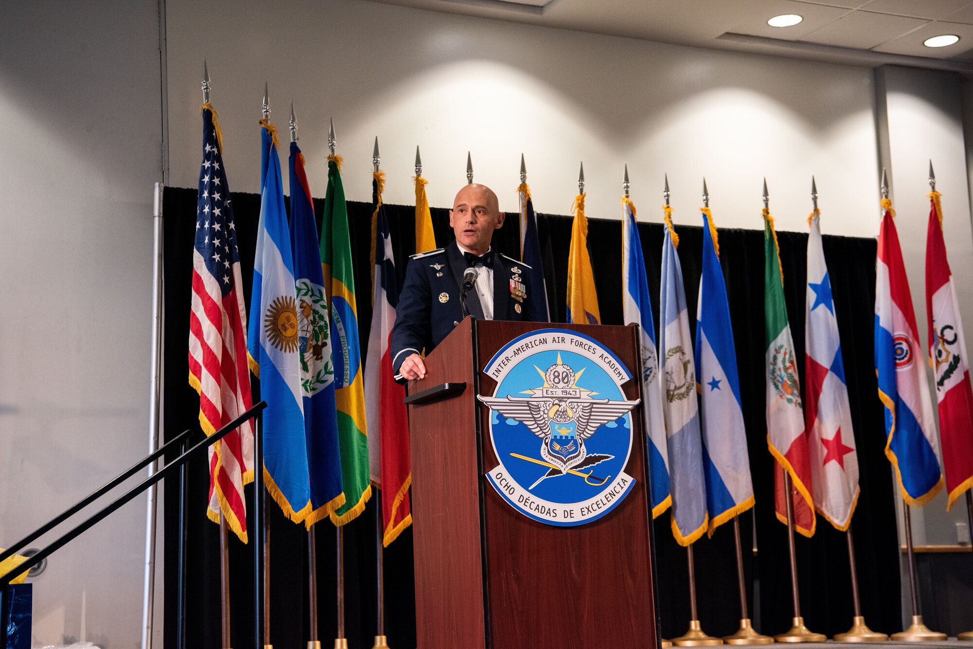 Col. José Jiménez, Jr., commandant of the Inter-American Air Forces Academy, looks up while speaking  at the IAAFA Graduation Banquet and 80th anniversary celebration, at San Antonio, Texas, April 26, 2023. More than 60 international military students from seven partner nations and the USAF graduated during the first training cycle of 2023. IAAFA provides instruction in professional military education and leadership, aircrew training and technical courses – all in Spanish. (U.S. Air Force photo by Vanessa R. Adame)