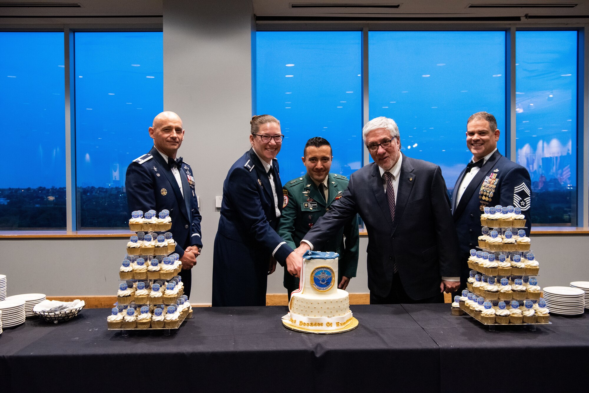 Col. Lauren Courchaine, 37th Training Wing Commander, Ambassador Luis Moreno and Capitan Jhonatan D. Escuraina Novoa of the Colombian Army are flanked by Col. José Jiménez, Jr., and Chief Master Sgt. Yusef Saad, IAAFA Senior Enlisted Leader, as they prepare to cut into the ceremonial cake. As recipient of the General Fernando Melgar Award, an outstanding student recognition, Novoa helped the leaders with the ceremonial cake cutting. More than 60 international military students from seven partner nations and the USAF graduated during the first training cycle of 2023. IAAFA provides instruction in professional military education and leadership, aircrew training and technical courses – all in Spanish.  (U.S. Air Force photo by Vanessa R. Adame)