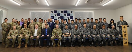  People gathered in a room for a group photo.