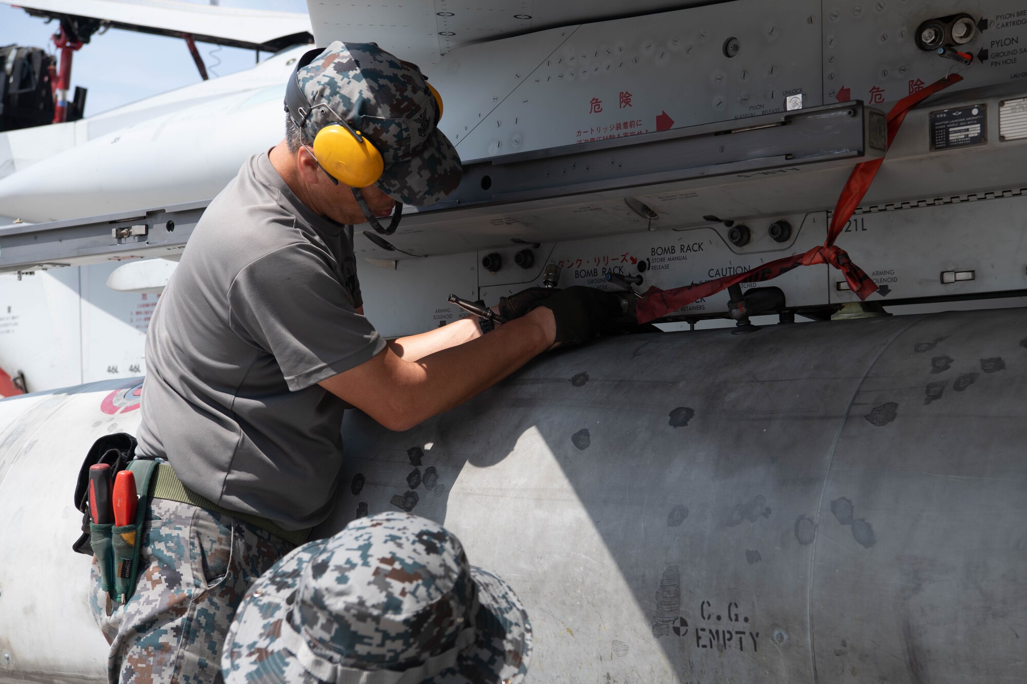 Japanese man secures holding rack for jet