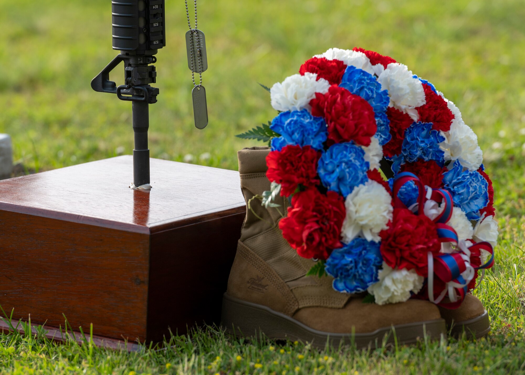 a wreath, boots, rifle, and dog tags