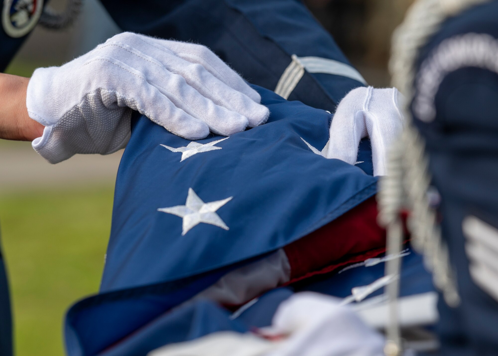 a closeup of a flag being folded by hour hands