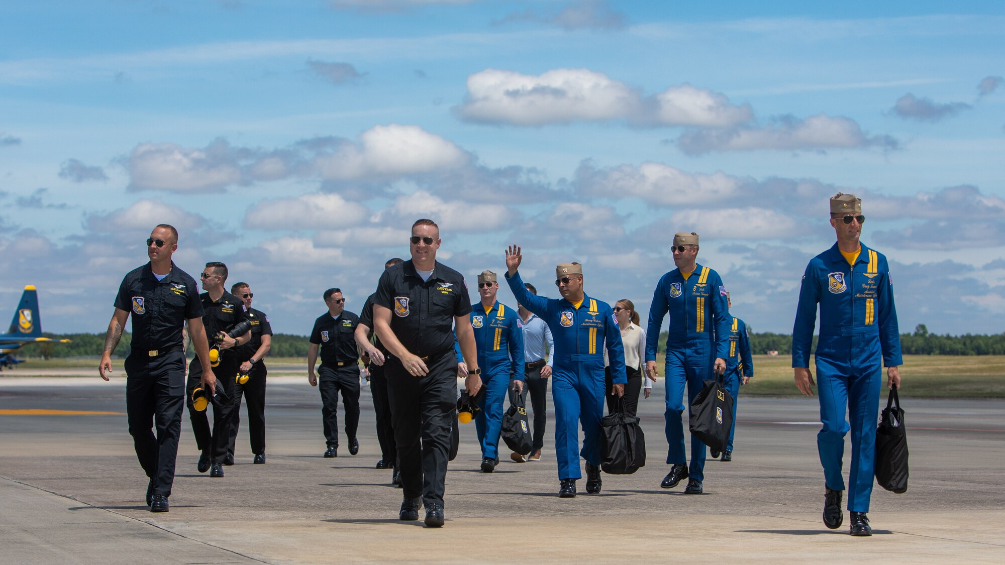 U.S. Marines and Sailors assigned to the Blue Angels walk across the flightline during the 2023 Wings Over Wayne air show at Seymour Johnson Air Force Base, North Carolina, May 20, 2023. Wings Over Wayne provides an opportunity for North Carolina residents and visitors from around the world to see how SJAFB builds to the future of airpower and displays a history of aircraft innovation and capabilities. (U.S. Air Force photo by Staff Sgt. Koby I. Saunders)