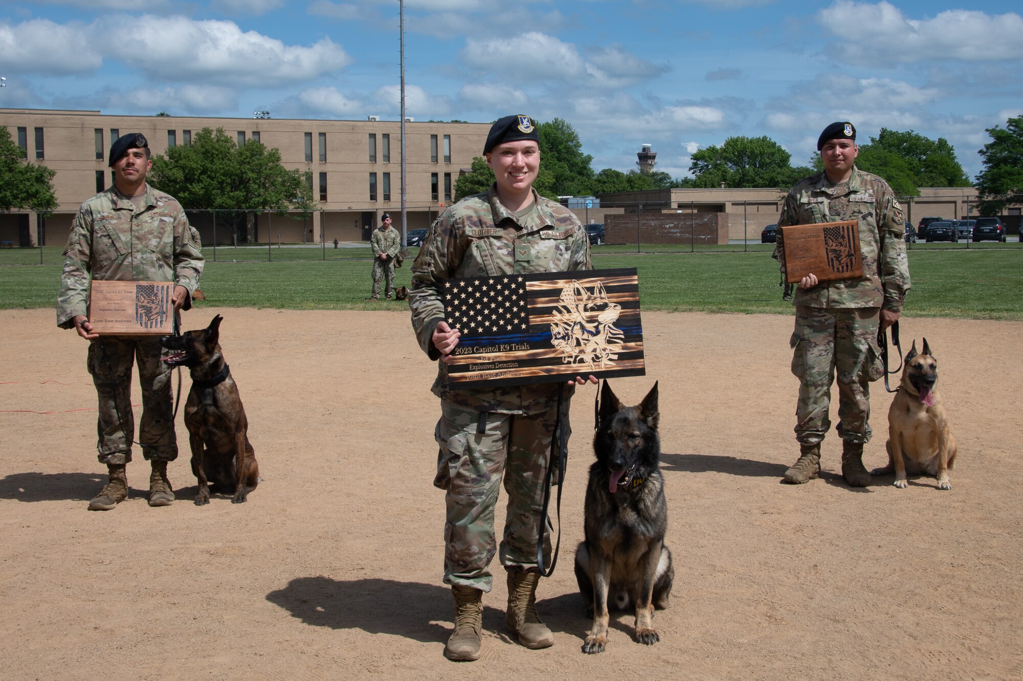 Men in uniform stand next to dogs.