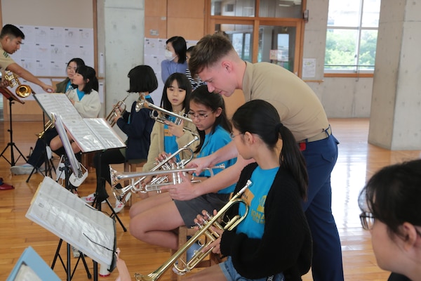 A member of the III MEF band coaches students on point during a sectional lesson for each instrument.
楽器ごとに分かれてのレッスンで、生徒らにポイントポイントで指導する第三海兵遠征軍音楽隊員。