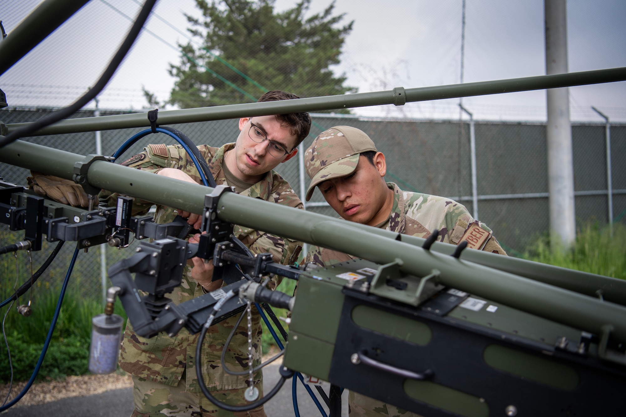 U.S. Air Force Senior Airman James Angeley, left, 607th Air Communications Squadron, radio maintenance technician, and U.S. Air Force Senior Airman Carlos Perez Ortiz, right, 607 ACOMS, radio frequency transmission system technician sets up a ground multiband terminal during exercise Enduring PACE, May 18, 2023, at Osan Air Base, Republic of Korea.