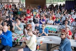 a large crowd in a picnic pavillion