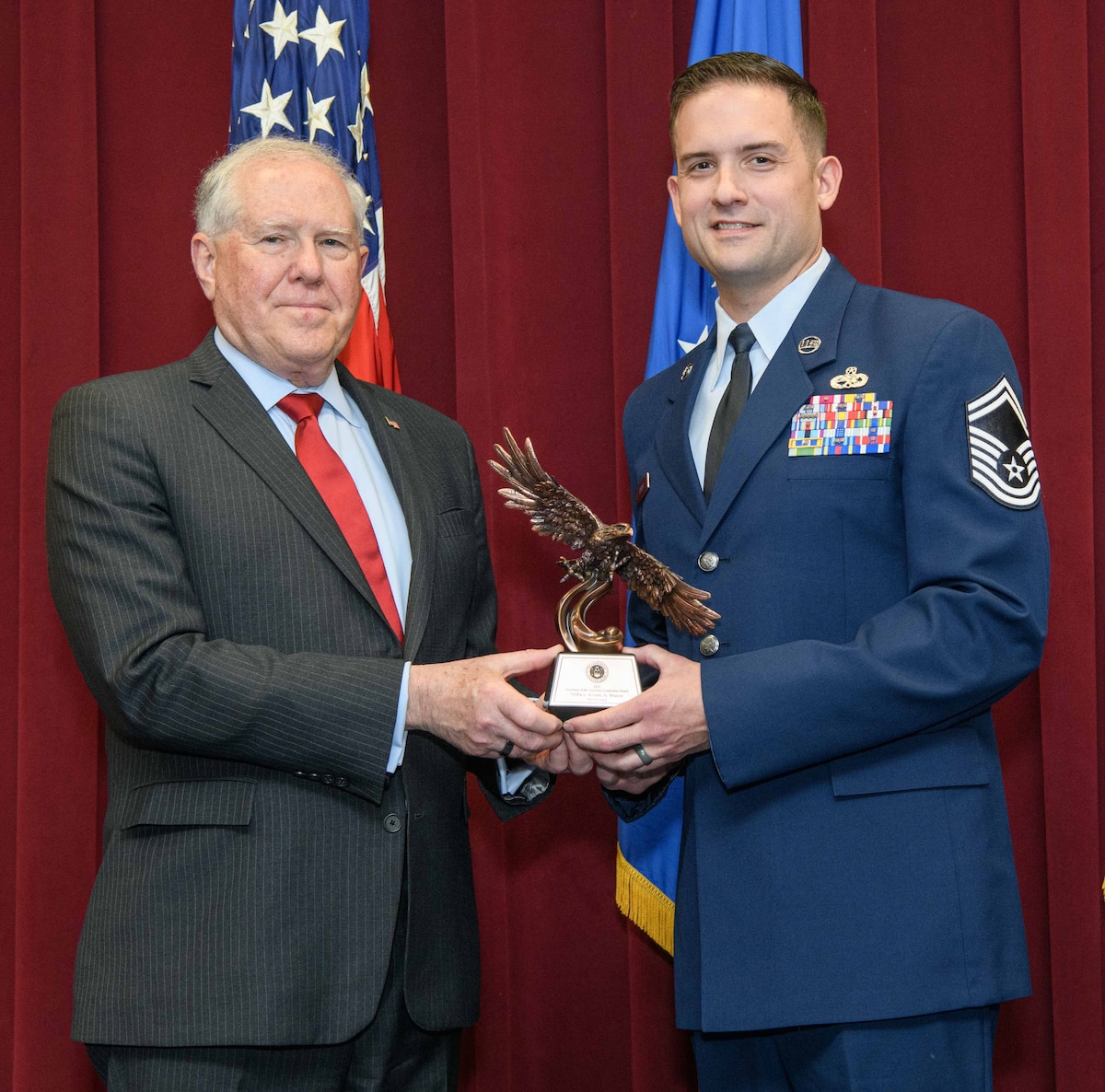 Secretary of the Air Force Frank Kendall presents a Secretary of the Air Force 2022 Leadership Award to Senior Master Sgt. Justin Baker