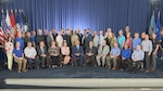 a large group pose for a photo on a stage