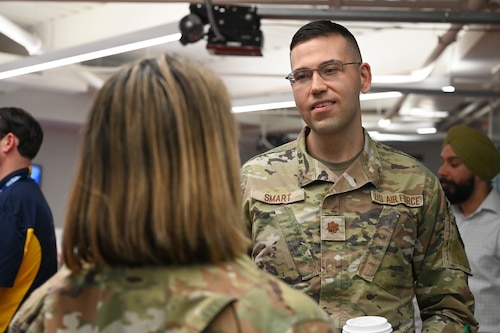 Two service members talk at symposium