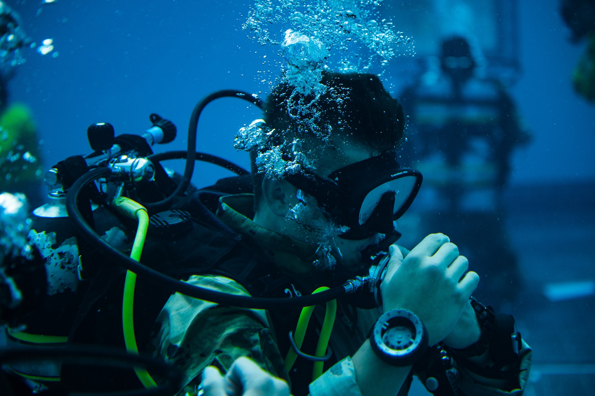 scuba diver in blows bubbles underwater